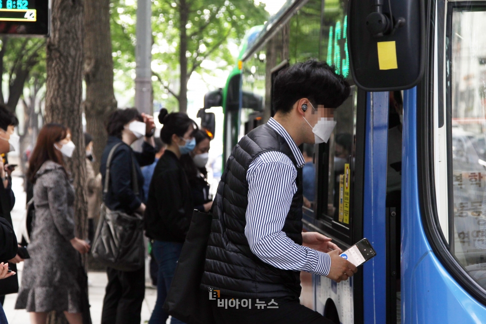마스크를 착용한 시민들이 버스에 오르고 있다.